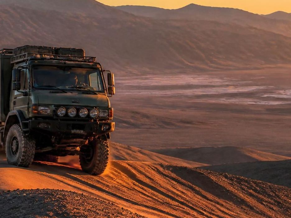 Expedition vehicle on a desert ridge above the Death Valley salt pan